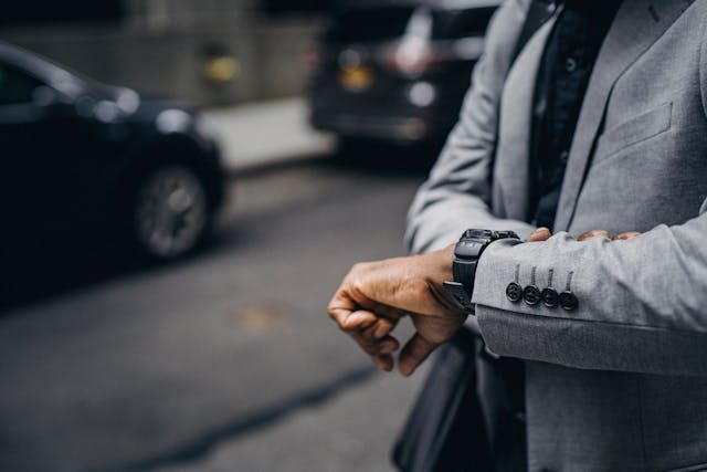 man looking at wrist watch waiting for rideshare