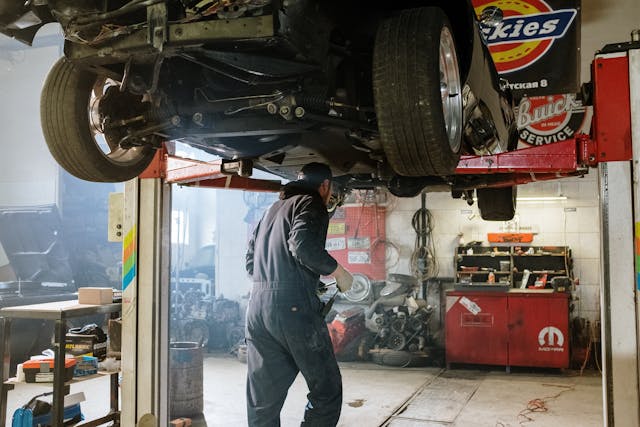 auto mechanic working on a car on a lift
