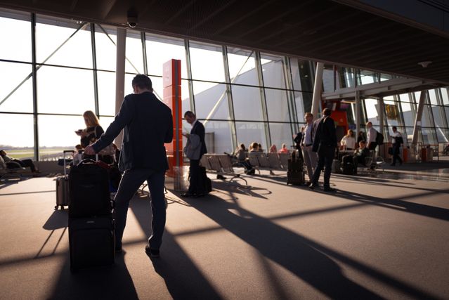 airport terminal with passengers holding luggage