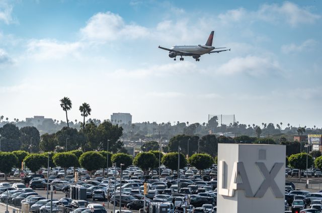 Lax airport with a plane flying in overhead